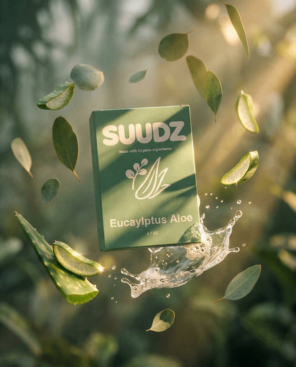SUUDZ Eucalyptus Aloe product packaging surrounded by leaves and water droplets