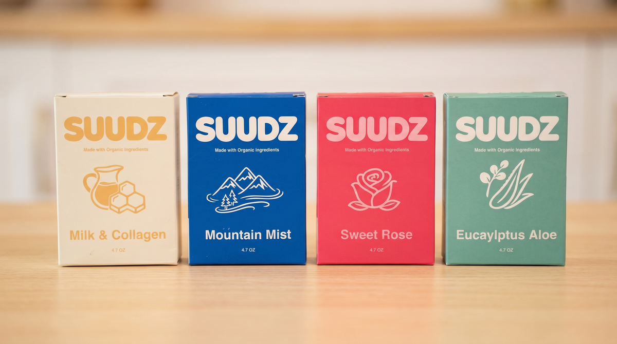 Four boxes of SUUdz with different scents on a wooden surface.