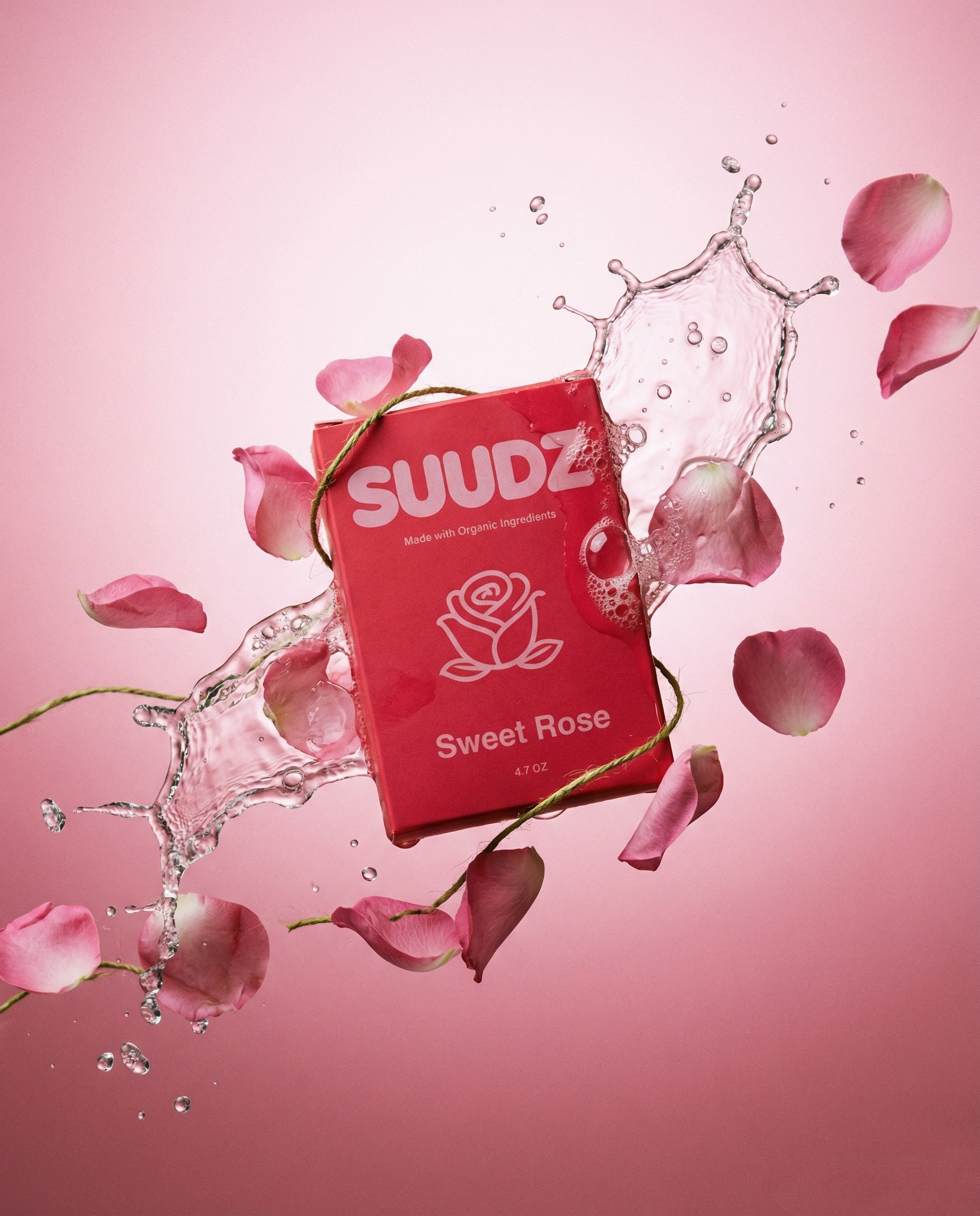 SUUDZ Sweet Rose product packaging with water splash and rose petals on a pink background