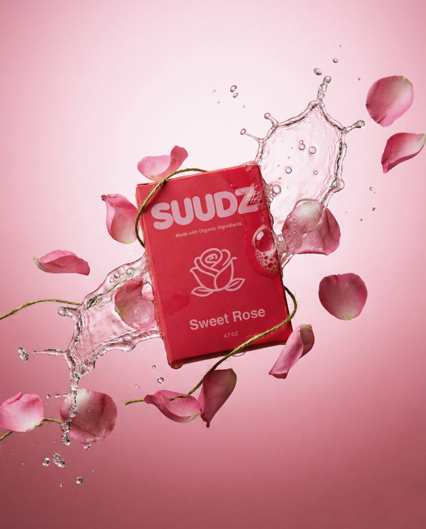 SUUDZ Sweet Rose product packaging with water splash and rose petals on a pink background