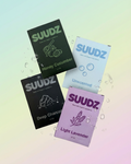SUUDZ product packaging with different scents on a gradient background