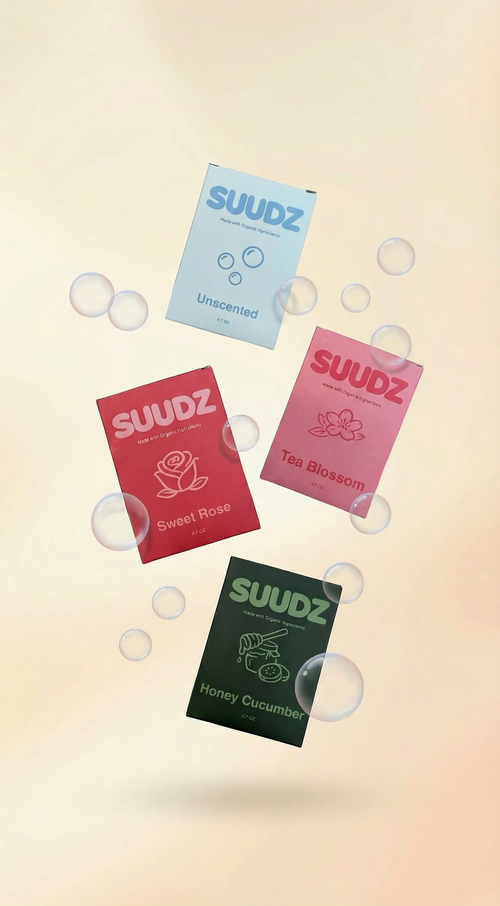 Four SUUDZ product packages with different scents on a gradient background